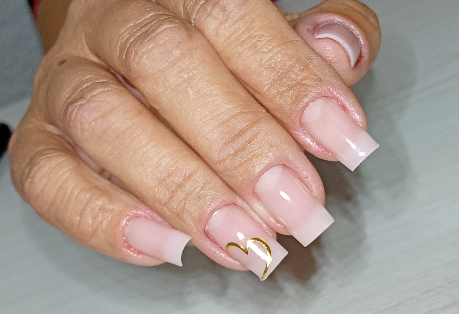 Alongamento nude com detalhe dourado em formato quadrado