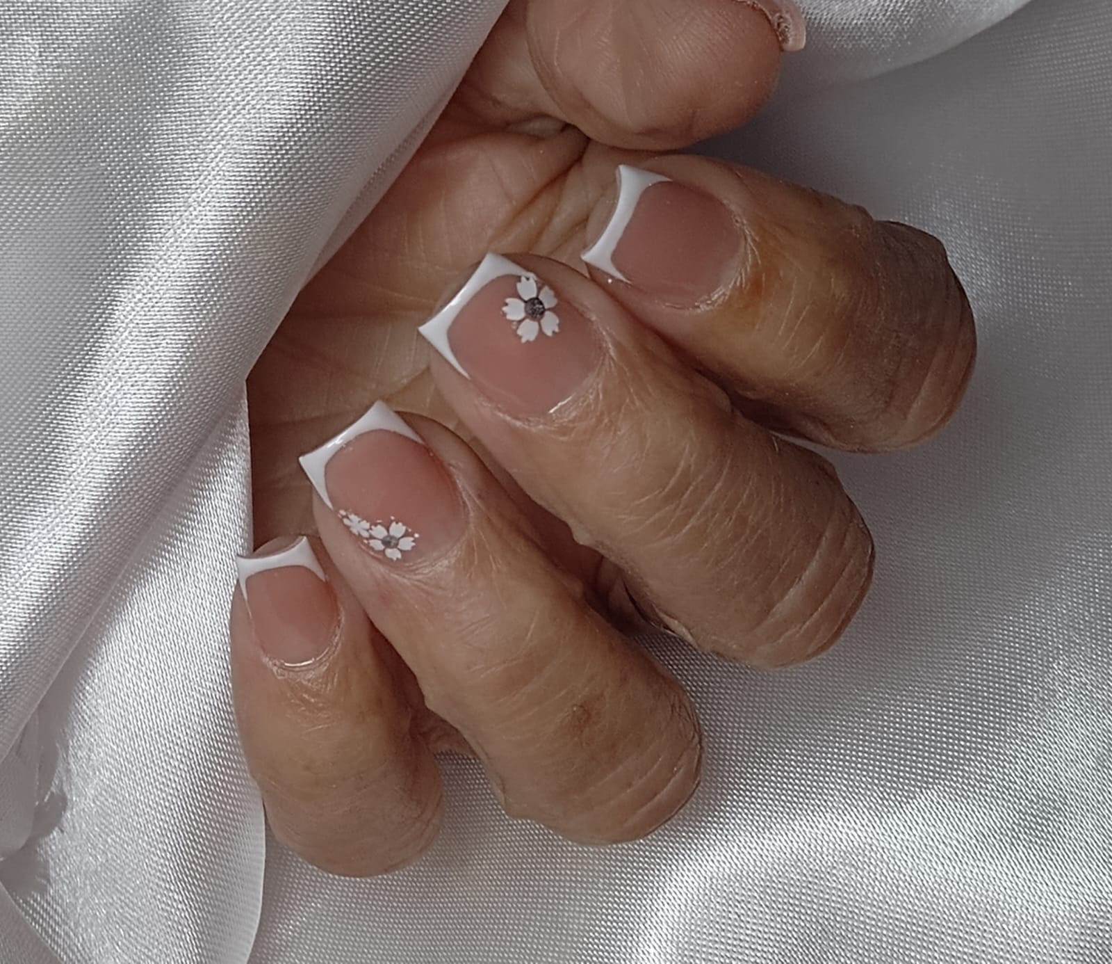 Unhas com esmaltação clara e acabamento limpo